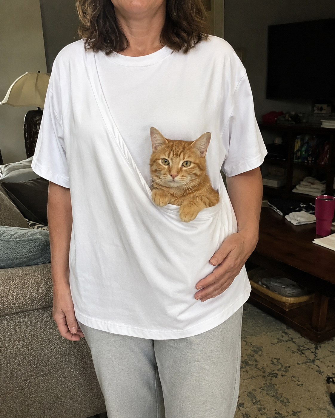 Cat comfortably sitting in PawPal front pouch at home